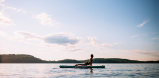 SUP Yoga. Wolf SUP Yoga practices upward facing dog on her paddleboard